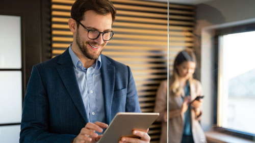 Happy professional successful business man using tablet and working in office
