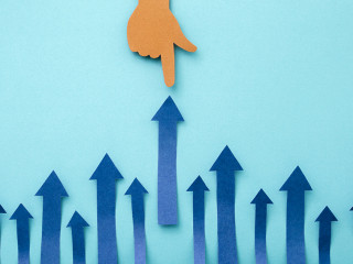 Hand pointing up arrow made of cut paper on blue background. Bus