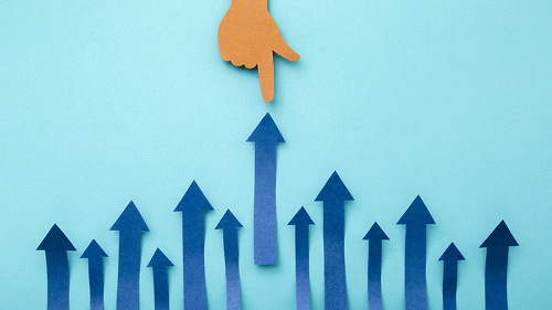 Hand pointing up arrow made of cut paper on blue background. Bus