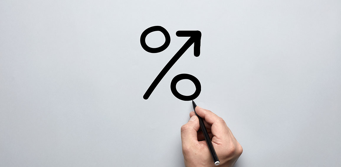 Male hand drawing a big percent sign on gray background with a p