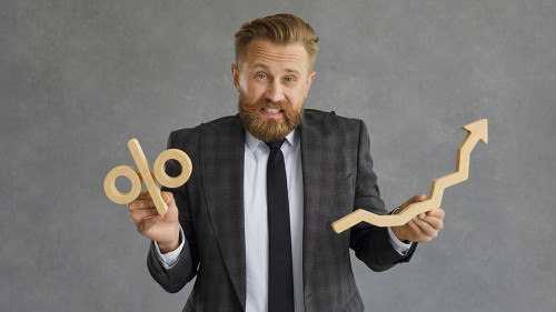 Businessman confused about taxes and money investment holding percent and arrow symbols