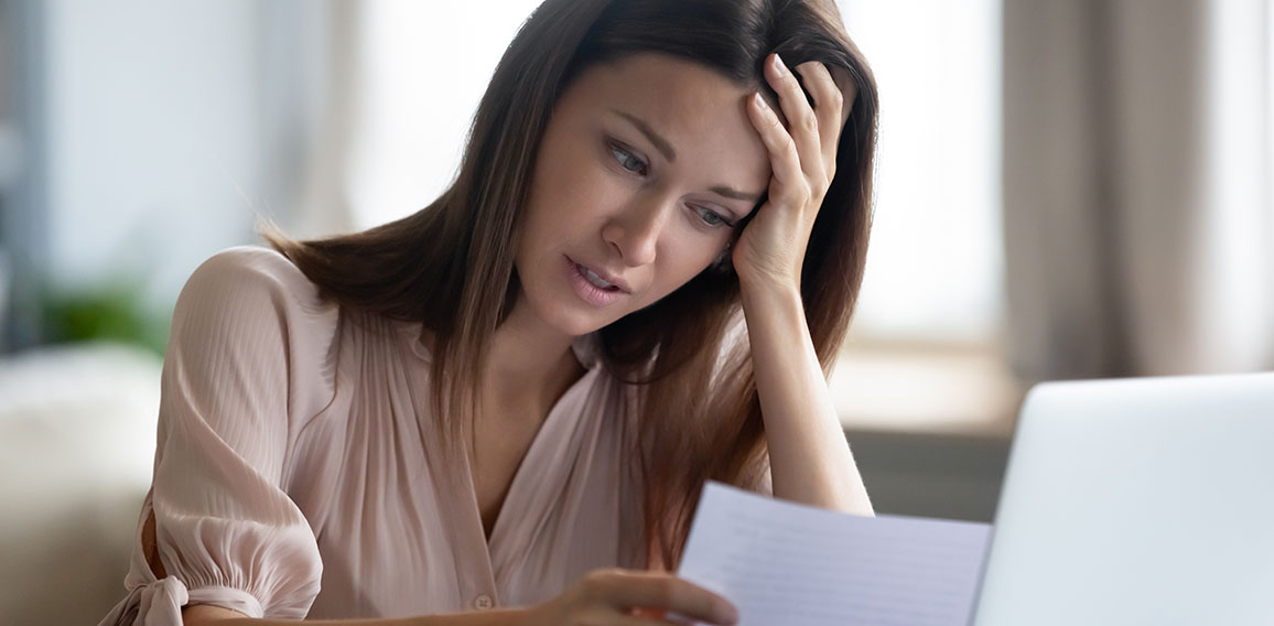 Unhappy woman holding paper, reading bad news in letter