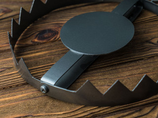 A big trap on a bear. on a wooden background.