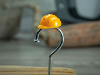 Carpentry nail shaped as question mark and helmet