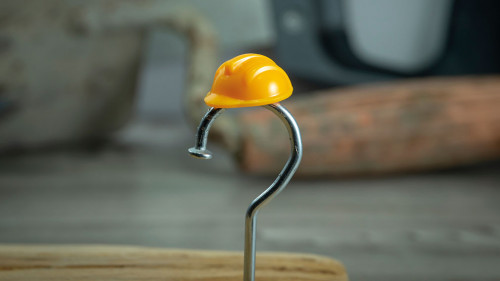 Carpentry nail shaped as question mark and helmet