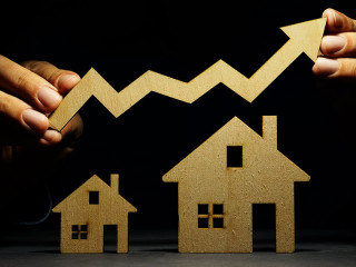 Property investment. Models of house and hand holding arrow.