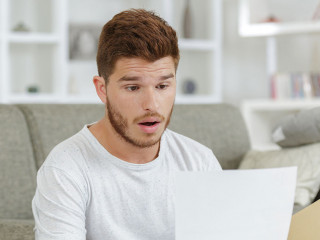 surprised man looking at paper