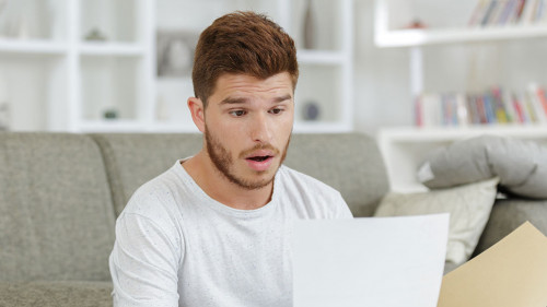 surprised man looking at paper