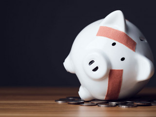 Financial problem, Bankrupt or fail in business concept. White piggy bank with plastic adhesive bandages on wooden desk with dark copy space wall background. Fail, Bankrupt or unsuccessful idea.