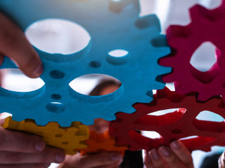 Teamwork of business people work together and combine pieces of gears