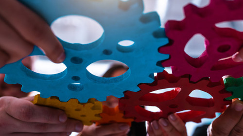 Teamwork of business people work together and combine pieces of gears