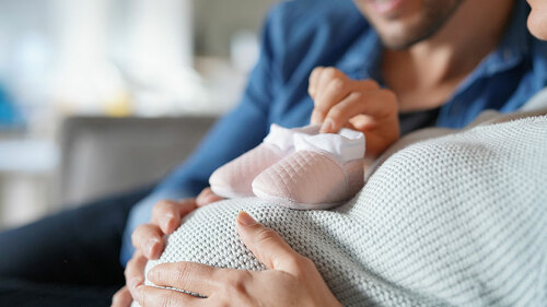 Mother and father to be at home expecting baby girl