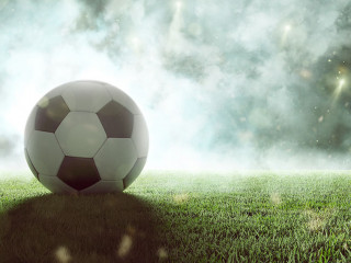 Fußball liegt auf Stadionrasen im Rauch