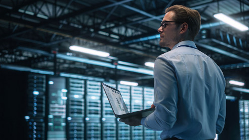 Data Center Male It Specialist Using Laptop while Working on Com