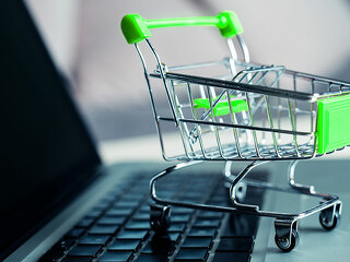 Shopping cart with laptop on the desk, online shopping concept.