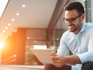 Portrait of businessman in glasses holding tablet
