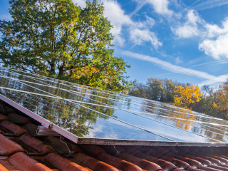 Wet photovoltaic modules in front of blue and cloudy autumn sky