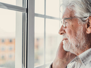 Pensive elderly mature senior man in eyeglasses looking in dista