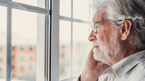 Pensive elderly mature senior man in eyeglasses looking in dista