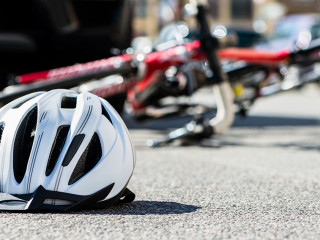Close-up of a bicycling helmet on the asphalt next to a bicycle