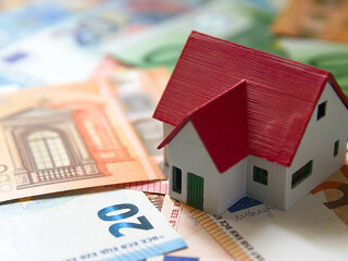 A miniature of a family house on euro banknotes represents the c