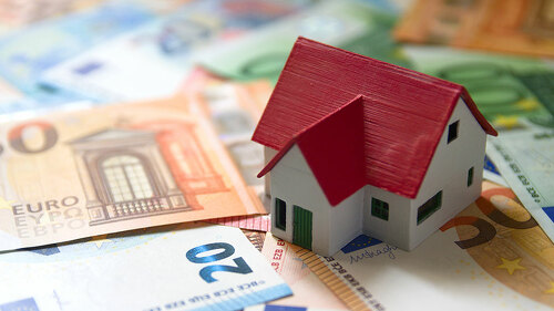 A miniature of a family house on euro banknotes represents the c