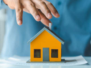 Broker agent with model toy house with documents signed purchase