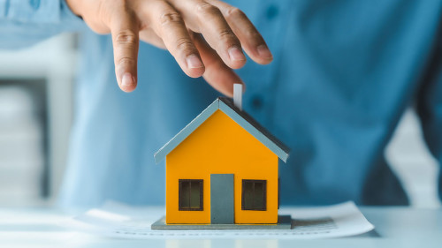 Broker agent with model toy house with documents signed purchase