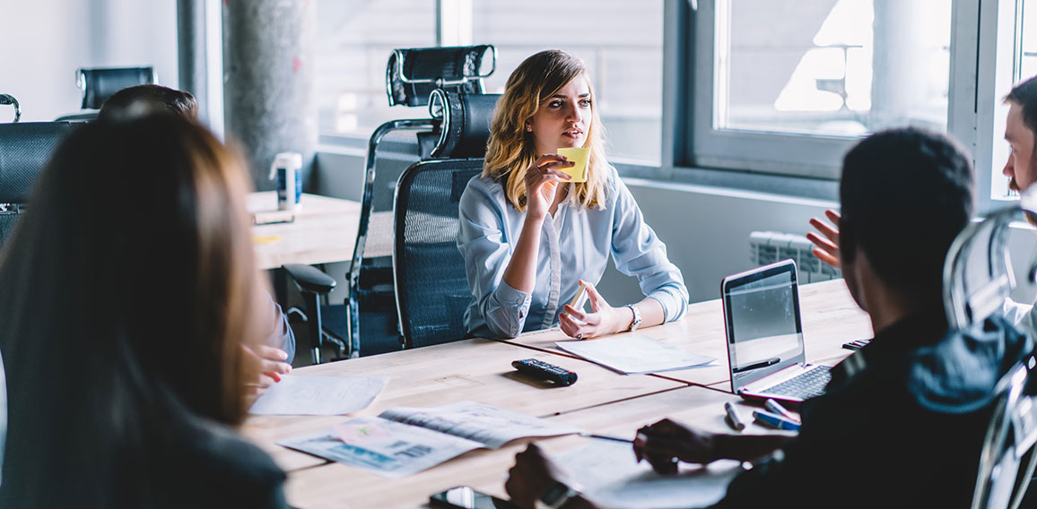 Creative young woman with sticker in hands discussing productive