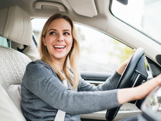 Young woman driver sitting in car, driving.