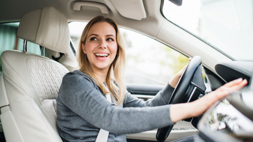 Young woman driver sitting in car, driving.