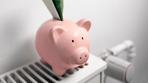piggy bank with money on radiator at home