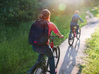 mother and son riding bikes in sunset nature