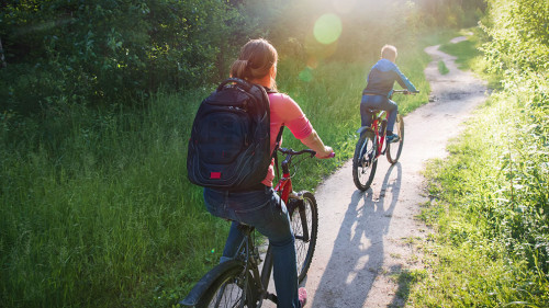 mother and son riding bikes in sunset nature