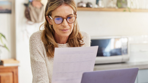 Budget, finance and retirement woman with laptop and paperwork for pension savings, bills or income investment on digital bank app. Elderly person with mortgage, financial document or tax management