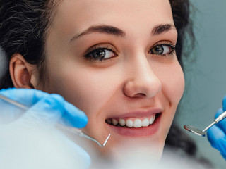 Smiling woman sitting in dentist chair ready for a dental check-