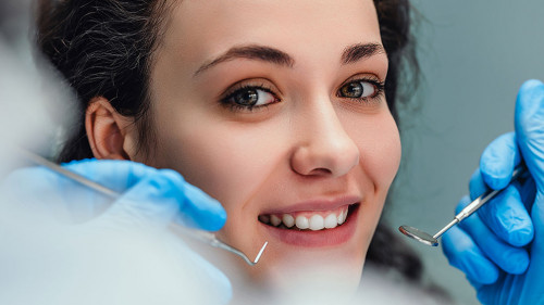 Smiling woman sitting in dentist chair ready for a dental check-