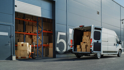 Outside of Logistics Warehouse with Open Door, Delivery Van Load