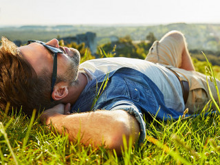Man lying on grass enjoying peaceful sunny day