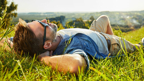 Man lying on grass enjoying peaceful sunny day
