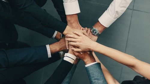 Diverse business team putting their hands together in a huddle of support and motivation