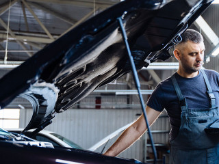 Auto service, repair, maintenance concept. Mechanic checks the car at the service station. Service maintenance of industrial to engine repair.