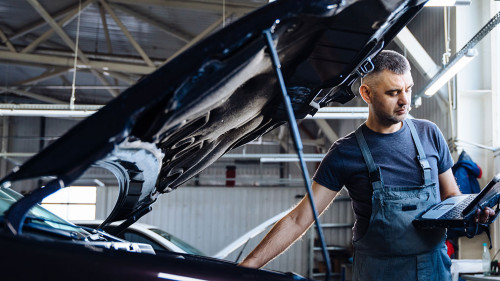 Auto service, repair, maintenance concept. Mechanic checks the car at the service station. Service maintenance of industrial to engine repair.