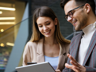 Two creative business people working on social media strategy using a digital tablet