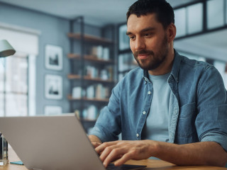 Handsome Caucasian Man Working on Laptop Computer while Sitting