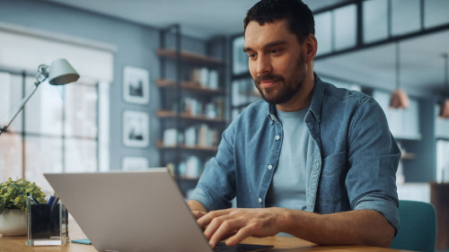Handsome Caucasian Man Working on Laptop Computer while Sitting