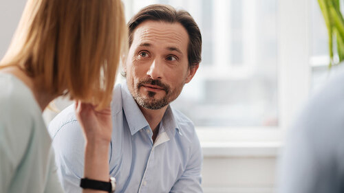 Very attentive man looking at his colleague