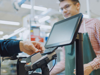 At the Supermarket: Checkout Counter Customer Pays with Smartpho