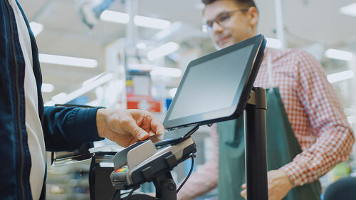 At the Supermarket: Checkout Counter Customer Pays with Smartpho