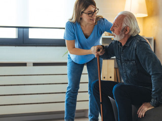Young caring nurse helping senior old elderly man grandfather wa